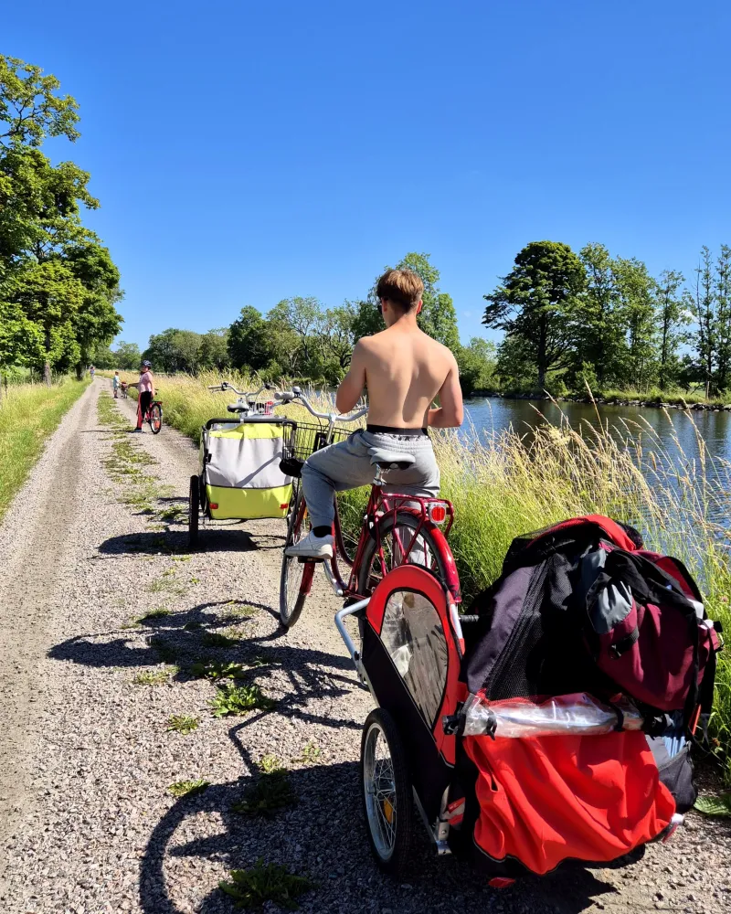 Pojke med cykelvagn har tagit paus för att dricka under cykelturen.